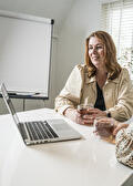 Petra Kamphuis aan tafel met laptop en een kop thee
